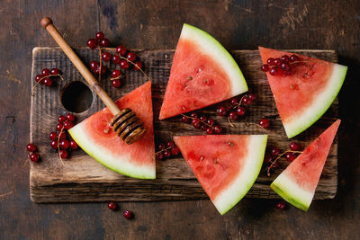 High angle view of watermelon with red currants on table