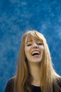 Close-up portrait of redhead woman against wall