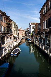 Boats in canal along buildings