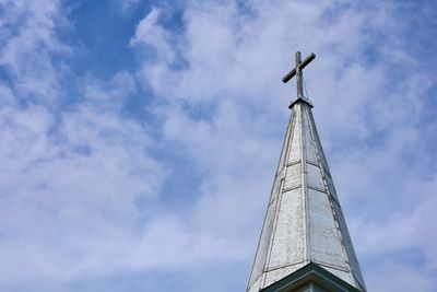 Low angle view of cross on building against sky