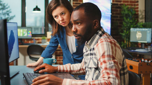 Portrait of young man using laptop at home