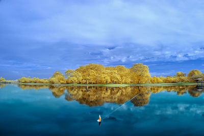 Scenic view of calm lake against cloudy sky