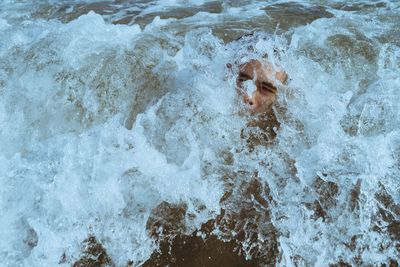 High angle view of shirtless man in sea