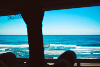 Sea seen through window against clear sky