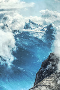 Scenic view of sea and snowcapped mountains against sky