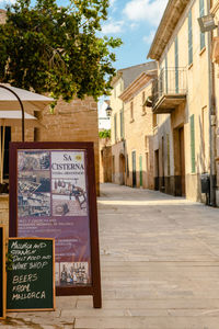 Information sign on footpath by buildings in city