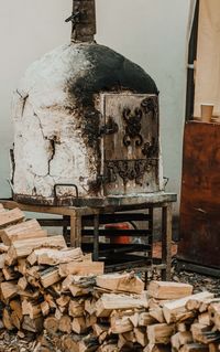 Stack of logs against building