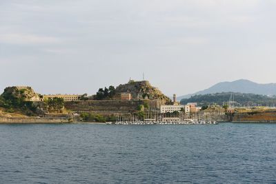 View of temple by sea against sky