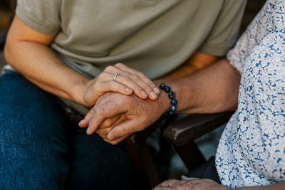 Female nurse consoling elderly woman sitting on bench