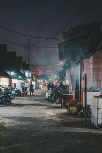 Road by buildings in city at night