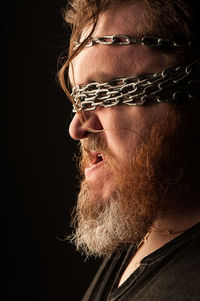 Portrait of man wearing eyeglasses against black background