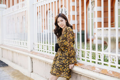 Portrait of woman standing against wall