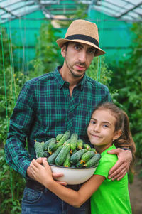 Portrait of young man standing in greenhouse