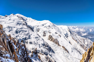 Scenic view of snowcapped mountains against clear blue sky