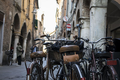 Bicycles parked on street amidst buildings in city