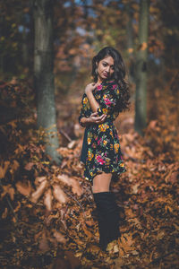 Full length portrait of woman standing in forest