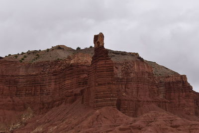 Low angle view of rock formation against cloudy sky