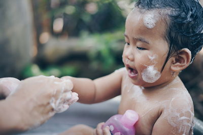 Cropped image of parent bathing cute baby girl