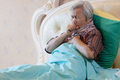 Midsection of woman sitting on bed