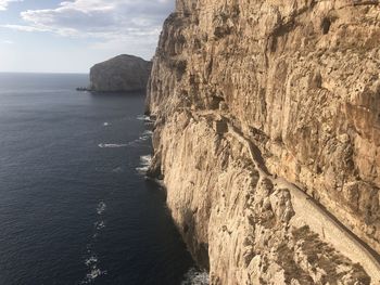 Scenic view of rock formation in sea against sky