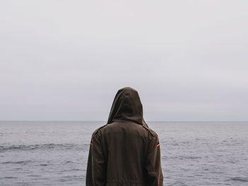Rear view of man standing against sea