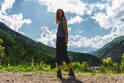 A female hiker standing and looking at the camera in the french alps during an adventure