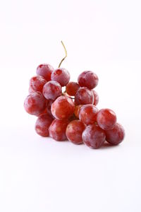 Close-up of grapes over white background