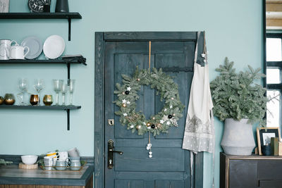 Christmas wreath on the wooden door in the kitchen in scandinavian style in blue tones