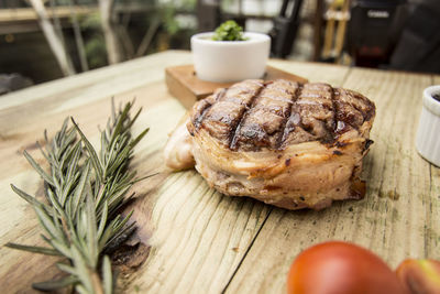 Close-up of grilled tuna with rosemary on wooden table