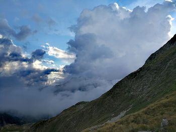 Low angle view of mountain against cloudy sky