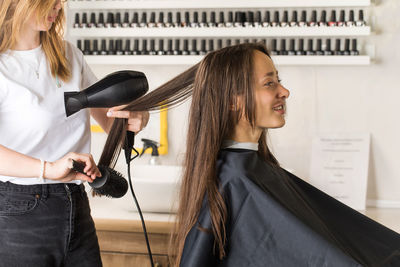 Side view of young woman using mobile phone