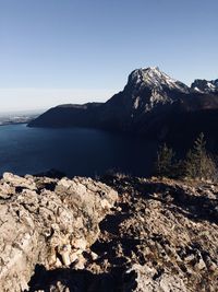 Scenic view of sea and mountains against clear sky