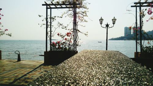 Close-up of street light by sea against clear sky