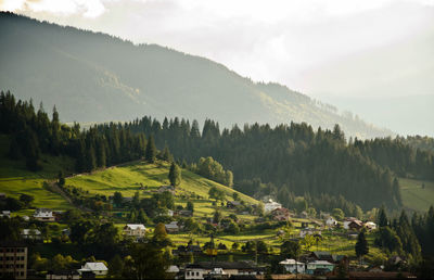 Scenic view of village on mountain against sky