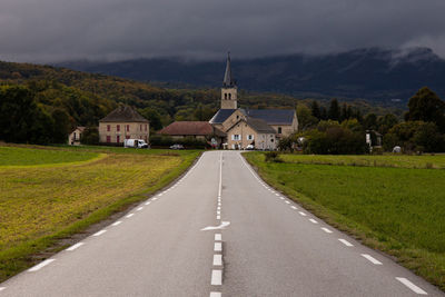 Road amidst buildings against sky