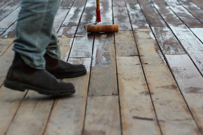 Low section of man standing on wooden floor