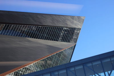 Low angle view of modern building against blue sky