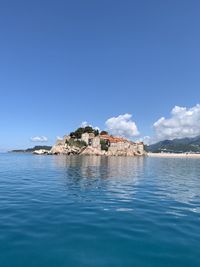 Scenic view of sea and buildings against blue sky