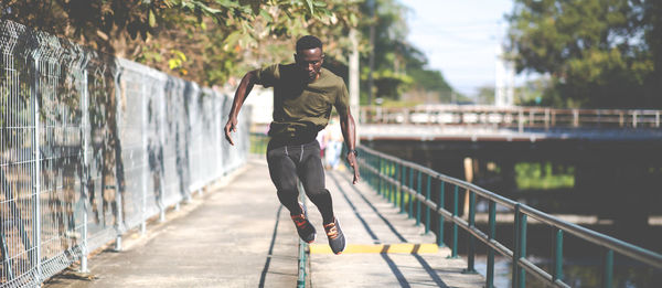 Full length of man on footbridge over footpath