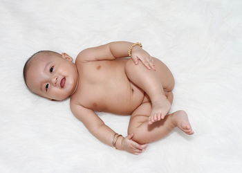 High angle view of cute baby boy lying on bed at home