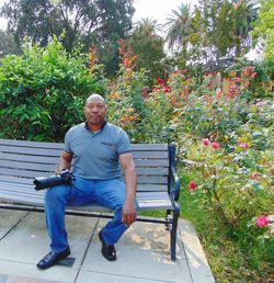 Portrait of man sitting on seat against plants