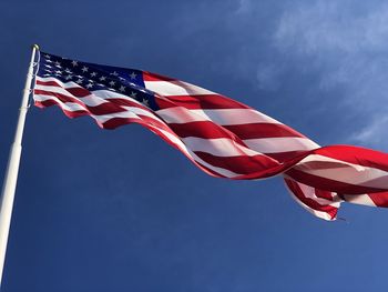 Low angle view of american flag against sky