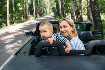 Portrait of happy friends sitting in car