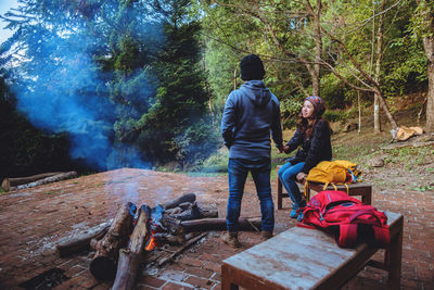 Rear view of couple walking in forest