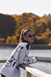 Portrait of young woman standing against wall