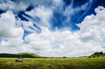 Scenic view of field against cloudy sky