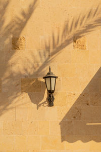 Shadows from palm trees on the light walls of a building with lantern. sunny day, travel lifestyle.