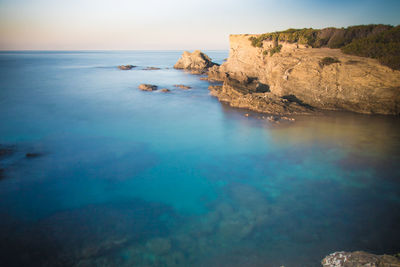 Rocks in sea against sky