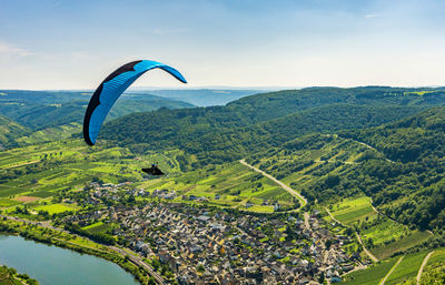 Scenic view of parachute over landscape against sky