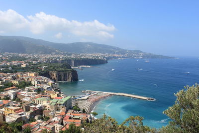 High angle view of townscape by sea against sky